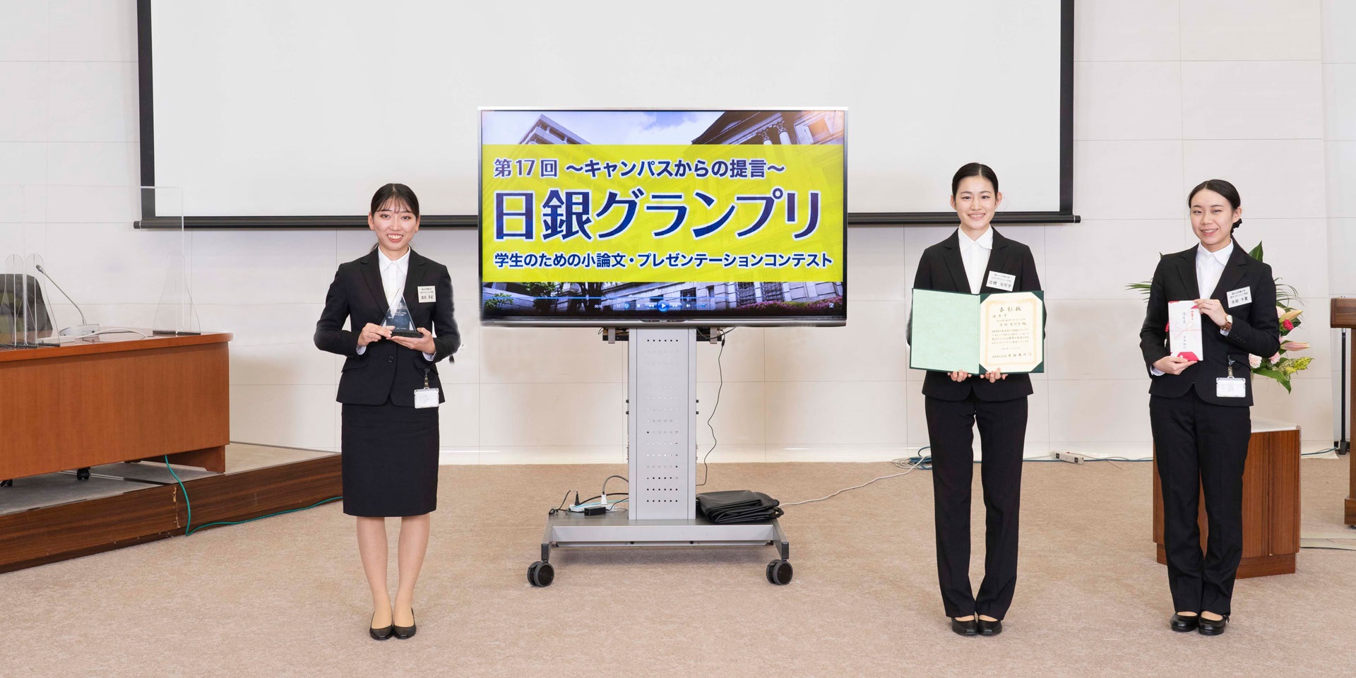 椙山女学園大学チームの学生3人が、間隔を空けて横一列に起立して記念撮影している様子