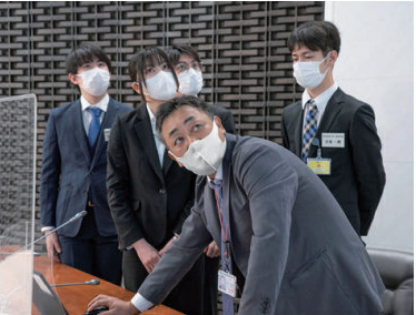 スタッフがパソコンの操作を説明している写真。