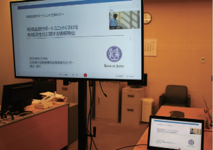 地域活性化に関するセミナーで使用する資料が、大型のスクリーンに映し出されている写真。