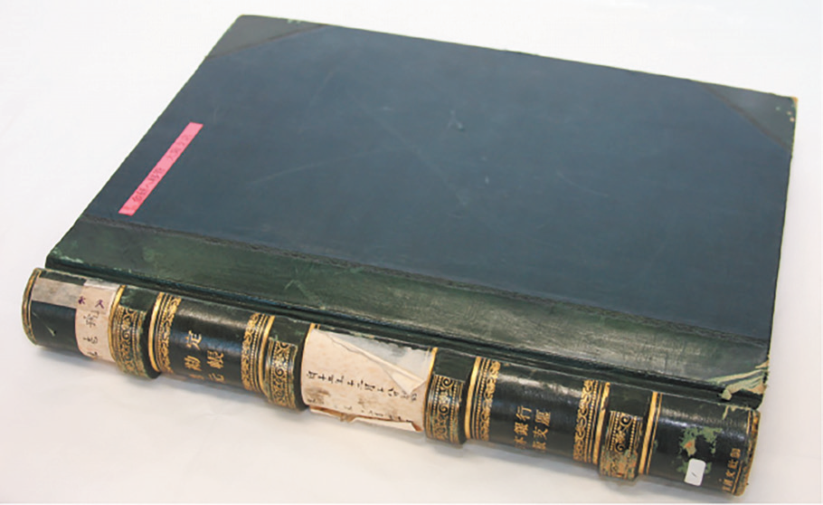 日本銀行大阪支店の帳簿の写真。表紙の色は濃紺。背表紙は緑色で、金色で文字と模様が印刷されている。