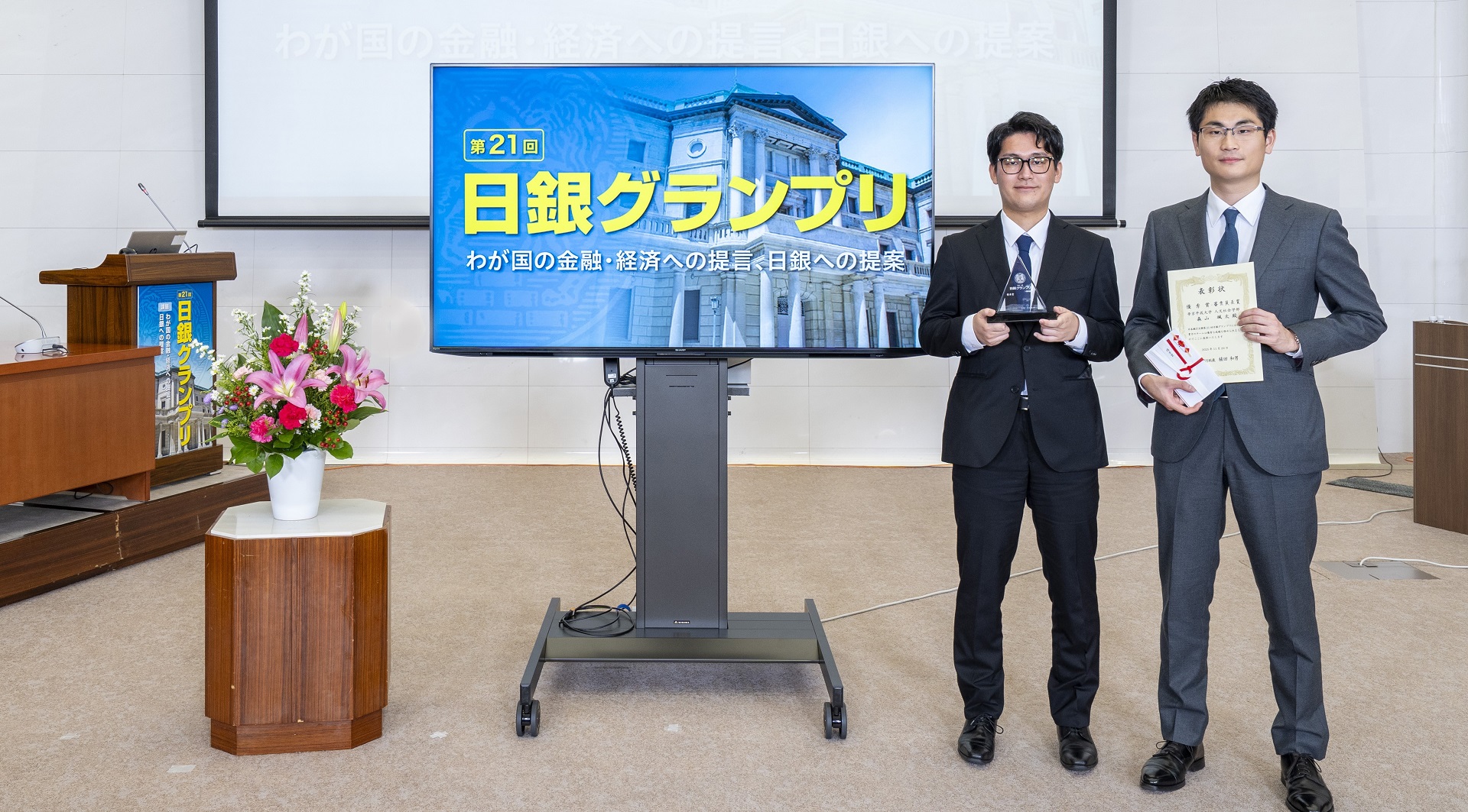 帝京平成大学チームの学生2人が、横一列に起立して記念撮影している様子