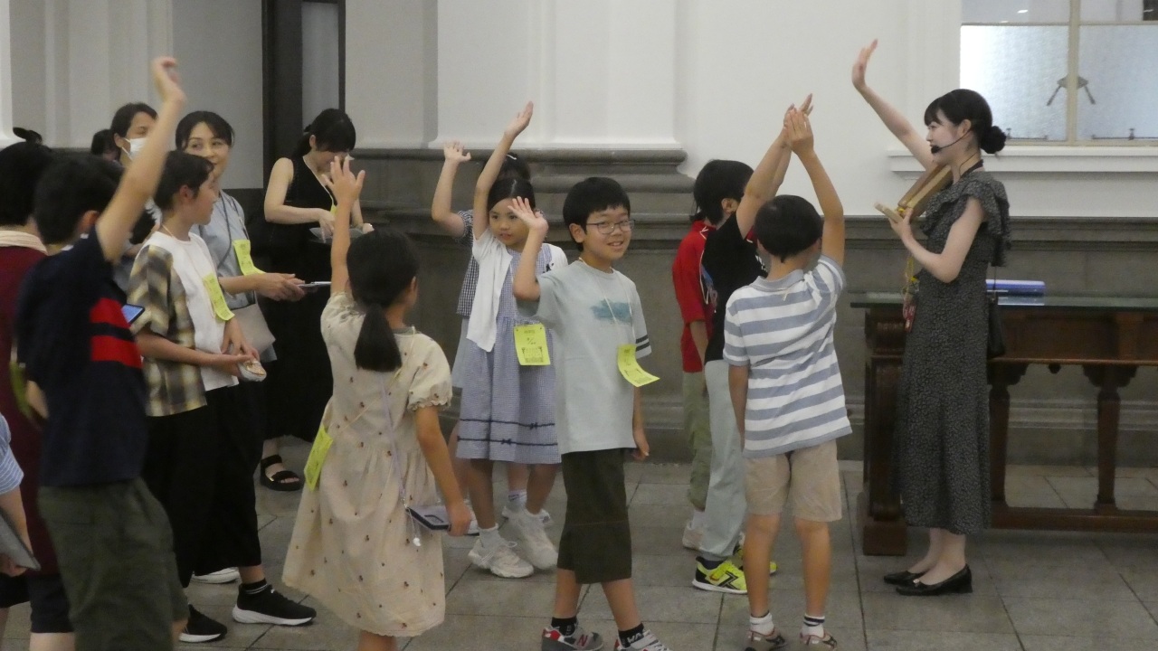 ガイド1人が、客溜にて、参加者全員に対してクイズを出している様子