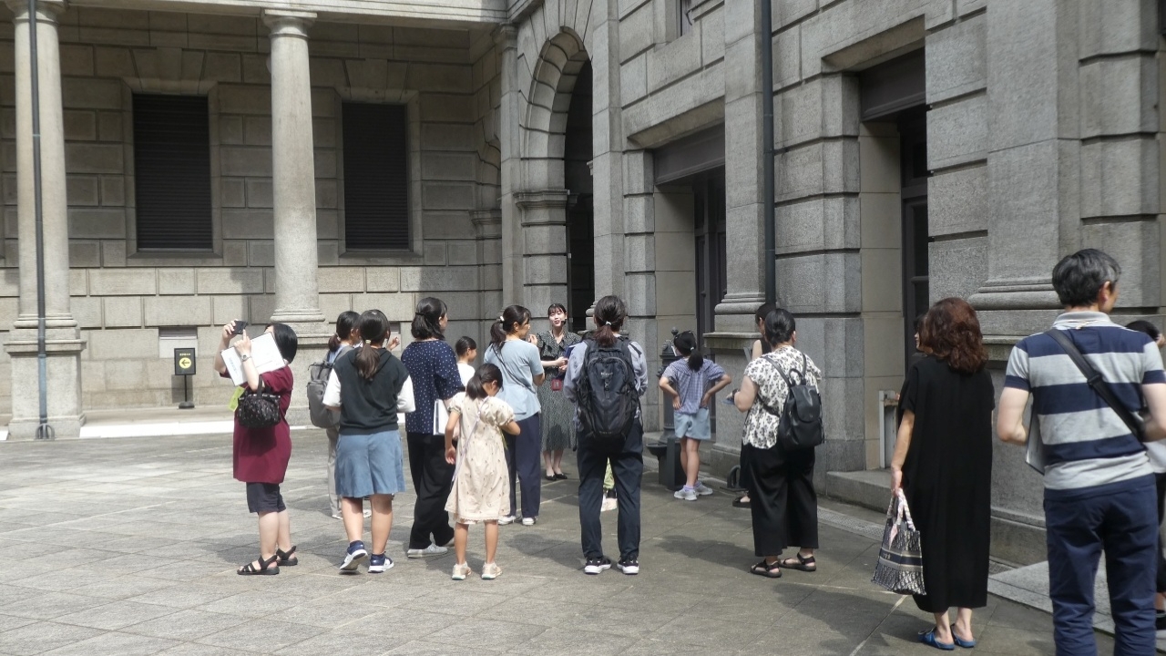 ガイド1人が、参加者全員に対して中庭の解説をしている様子