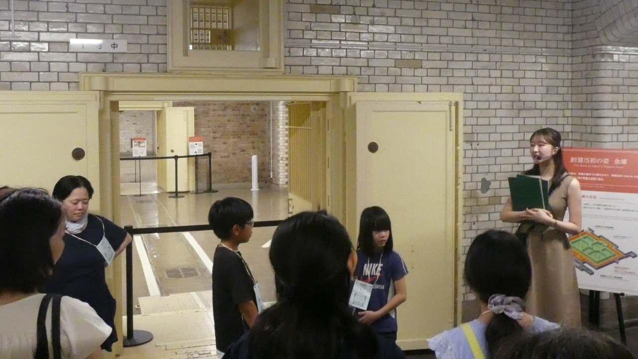 ガイド1人が、参加者全員に対して地下金庫の扉を解説している様子