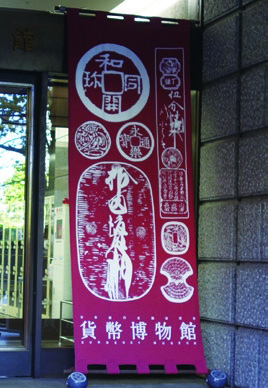 貨幣博物館の玄関に飾られた屋号の垂れ幕