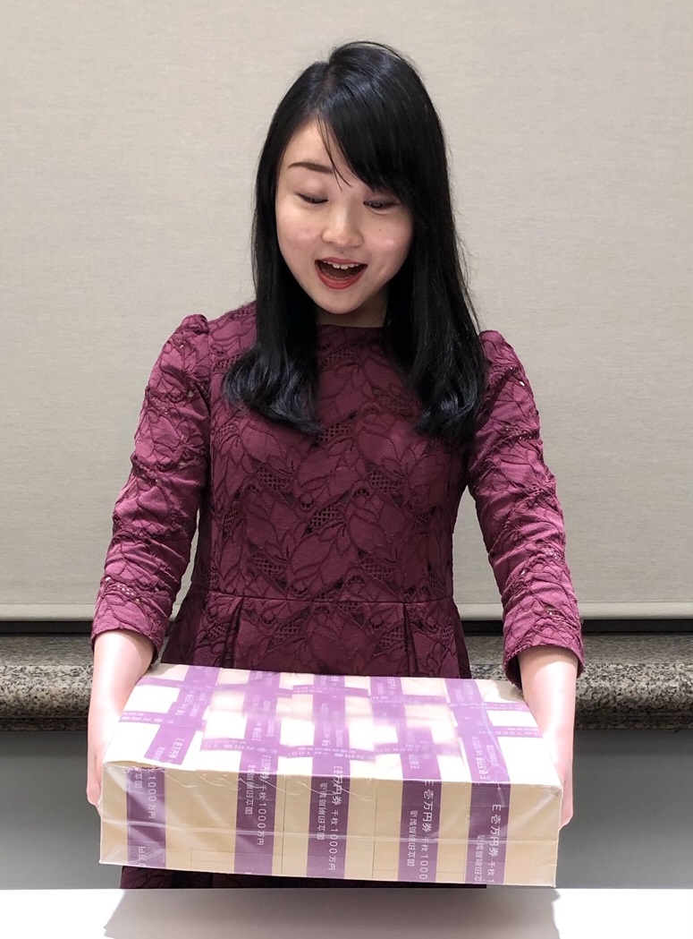 Image: holding a replica package of 100 million yen