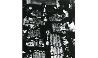 Image: staff members pasting stickers on old yen notes verifying their validity for circulation under the new yen system