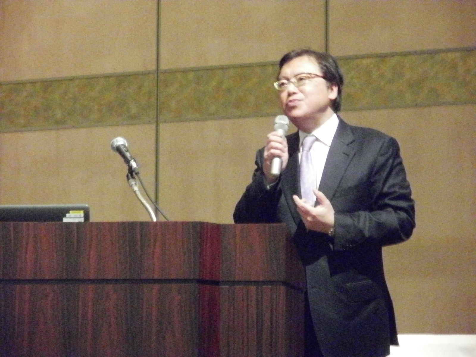 マイクを持って話している講演者の写真