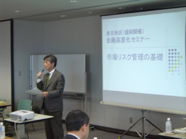 パネリストとスライドを映した写真