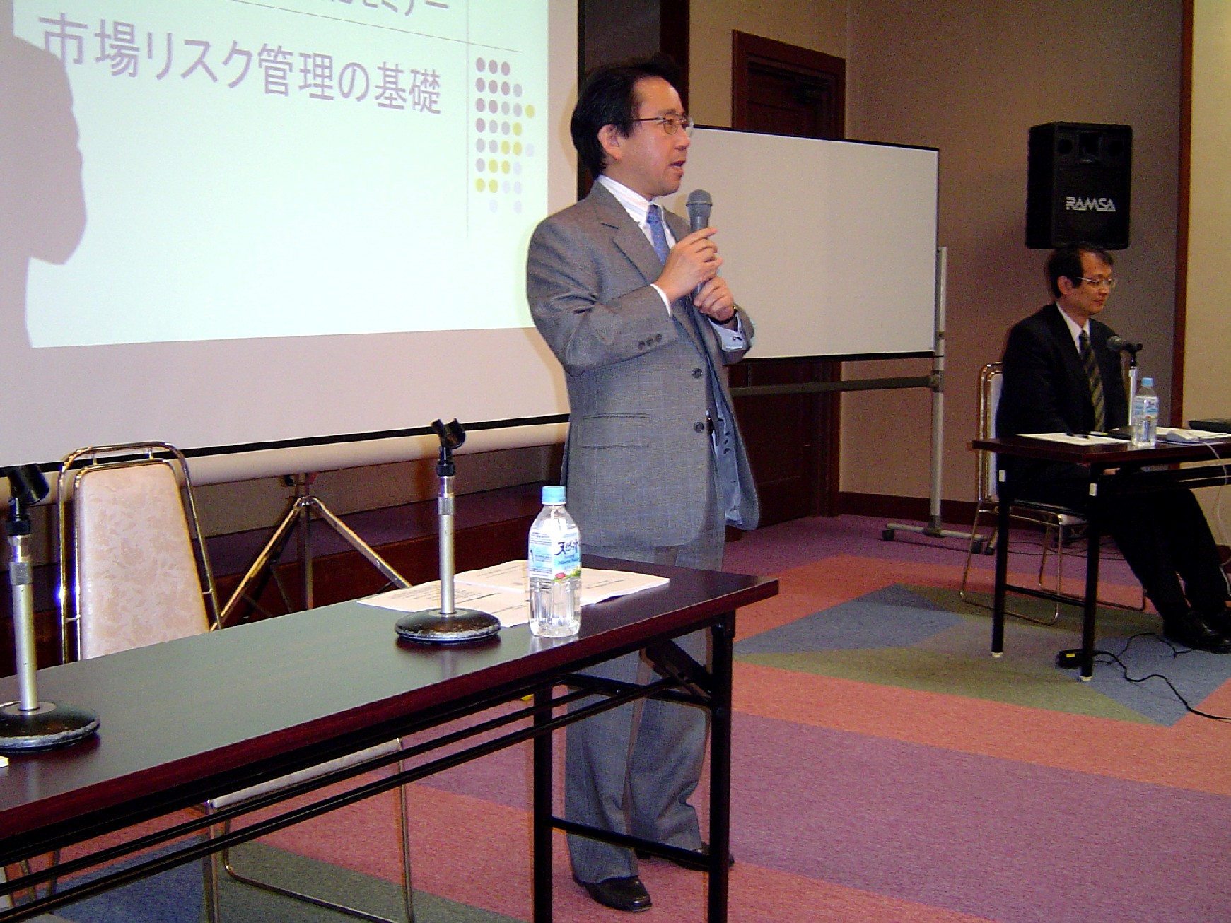 パネリストがマイクを持って講演をしている写真