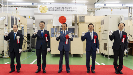 打初め者が打初めされた貨幣を手に取って記念撮影している写真